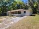 Charming single-story home with a screen door entry and a lush, wooded front yard at 318 S Massachusetts Ave, Deland, FL 32724