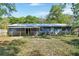 Back of house with a covered patio and a large yard with mature trees at 321 Wade Ave, Deland, FL 32724