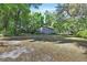 Spacious backyard with mature trees, an outbuilding, and a fire pit at 321 Wade Ave, Deland, FL 32724