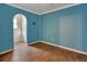 This room is has an archway, wood floors and blue walls and a door leading to another room at 321 Wade Ave, Deland, FL 32724