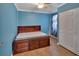 Bright bedroom featuring wood floors, blue walls, closet, and a platform bed with drawer storage at 321 Wade Ave, Deland, FL 32724
