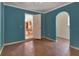 View of the room with an archway and wood floors leading into the dining area and kitchen at 321 Wade Ave, Deland, FL 32724