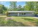 Charming single-story home featuring a metal roof, well-maintained lawn, and mature trees at 321 Wade Ave, Deland, FL 32724