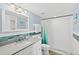 Updated bathroom with blue accent tiles, modern vanity, shower with glass door, and updated light fixtures at 3333 S Atlantic Ave # 2202, Daytona Beach, FL 32118