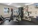 Well-lit community gym with a weight machine and dumbbell rack with view of palm tree outside windows at 3333 S Atlantic Ave # 2202, Daytona Beach, FL 32118