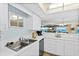 Clean, white kitchen featuring stainless steel appliances and a sink with a beautiful view to the living room at 3333 S Atlantic Ave # 2202, Daytona Beach, FL 32118