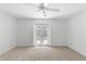 Bedroom with ceiling fan, neutral carpet, and access to the patio via French doors at 36 Sand Dollar Dr, Ormond Beach, FL 32176