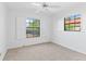 Well-lit bedroom with a ceiling fan and two windows showcasing the outdoor scenery at 36 Sand Dollar Dr, Ormond Beach, FL 32176