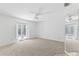 Bedroom with neutral carpet, white walls, ceiling fan, and exterior access at 36 Sand Dollar Dr, Ormond Beach, FL 32176