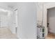 Bright hallway featuring tile floors, leading to a bathroom and a water heater closet at 36 Sand Dollar Dr, Ormond Beach, FL 32176