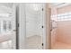 Walk-in closet with rod and wire shelving, attached to bathroom with pink shower at 36 Sand Dollar Dr, Ormond Beach, FL 32176