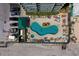Aerial view of a condominium with an in-ground pool, lounge chairs, and parking at 3647 S Atlantic Ave # 5B, Daytona Beach, FL 32118