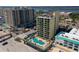 Beautiful aerial view of a condominium with a blue in-ground pool, lounge chairs, and parking at 3647 S Atlantic Ave # 5B, Daytona Beach, FL 32118