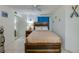 Charming bedroom features a rustic wood frame bed, a ceiling fan, white tiled floors, and closet at 3647 S Atlantic Ave # 5B, Daytona Beach, FL 32118