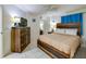 Bedroom with rustic furniture, including a wooden bed frame and dresser, complemented by tile flooring and bright accents at 3647 S Atlantic Ave # 5B, Daytona Beach, FL 32118