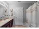 Well-lit bathroom includes a vanity with storage and a patterned shower curtain at 3825 Arborvitae Way, Deland, FL 32724