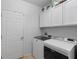 Bright laundry room featuring modern white cabinets and Maytag washer and dryer at 3825 Arborvitae Way, Deland, FL 32724