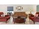 Inviting living room featuring a leather sofa and red armchairs around a wooden coffee table at 3825 Arborvitae Way, Deland, FL 32724