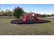 Brightly colored playground equipment sits on a mulch bed surrounded by a dark metal fence at 3825 Arborvitae Way, Deland, FL 32724