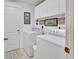 Well-lit laundry room with washer, dryer, white cabinets, and 'Home Sweet Home' decor at 47 Spring Glen Dr, Debary, FL 32713