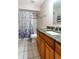 Well-lit bathroom boasts tiled floors, granite counters, wood cabinets, and shower-tub combo at 50 Lake Dr # 1/2, Debary, FL 32713