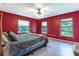 Primary bedroom with hardwood floors, red accent wall, and bright natural light at 50 Lake Dr # 1/2, Debary, FL 32713