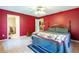 Primary bedroom with hardwood floors, ceiling fan, red accent wall, and ensuite bath at 50 Lake Dr # 1/2, Debary, FL 32713