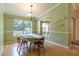 Bright dining room features hardwood floors, a charming chandelier, and large windows overlooking the landscaped yard at 50 Lake Dr # 1/2, Debary, FL 32713