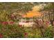 Scenic water view featuring blooming azaleas and the reflection of homes at sunset at 50 Lake Dr # 1/2, Debary, FL 32713