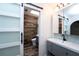 Bright bathroom with wood-look tile, a vanity with modern fixtures, and a sliding barn door at 511 Powers Ave, Port Orange, FL 32127