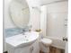 Cozy bathroom with a sink, toilet, vanity, round mirror, and shower-tub combo with new tiled walls at 511 Powers Ave, Port Orange, FL 32127