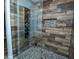 Walk-in shower featuring a pebble floor, multi-jet system, and wood-look tile at 511 Powers Ave, Port Orange, FL 32127