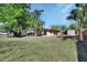 Exterior featuring a grassy yard and lush trees surrounding a neutral-toned house at 530 Taylor Dr, Orange City, FL 32763