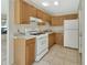 Functional kitchen with wood cabinets, white appliances, and tile flooring at 530 Taylor Dr, Orange City, FL 32763