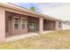 Covered patio with ceiling fan outside a house with dark tan siding at 69 Grey Dapple Way, Ormond Beach, FL 32174