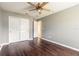 Bedroom featuring a ceiling fan, dark wood-like floors and a closet with sliding doors at 69 Grey Dapple Way, Ormond Beach, FL 32174