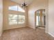 Living room with large window, chandelier, tile floor, and archways to other spaces at 69 Grey Dapple Way, Ormond Beach, FL 32174