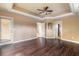 Primary bedroom with dark wood floors, tray ceiling, and doorways leading to other rooms at 69 Grey Dapple Way, Ormond Beach, FL 32174