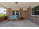 Relaxing front porch with a swing, brick accents, and a charming front door at 7 Kathy Dr, Ormond Beach, FL 32176