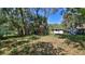 Expansive backyard with mature trees surrounding the home and storage shed at 709 Cedar St, Daytona Beach, FL 32114