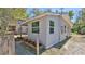 Side exterior view of this home featuring a stone planting bed, neutral paint, and mature trees at 709 Cedar St, Daytona Beach, FL 32114