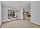 Bright dining room featuring a contemporary chandelier, large window, and neutral carpet throughout the house at 715 Oak Ter, Orange City, FL 32763
