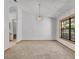 Bright dining room featuring a contemporary chandelier, large window, and neutral carpet throughout the house at 715 Oak Ter, Orange City, FL 32763