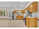 Well-lit kitchen featuring stainless steel appliances, wood cabinets, and a window overlooking the backyard at 715 Oak Ter, Orange City, FL 32763