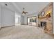 Bright, open living room featuring a brick fireplace and sliding glass doors to the outdoor space at 715 Oak Ter, Orange City, FL 32763