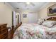 Bright bedroom with wood floors, ceiling fan, floral bedding, and ensuite bathroom at 7462 Se 172Nd Fieldcrest St, The Villages, FL 32162