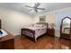 Comfortable bedroom with a floral bedspread, hardwood floors, and ceiling fan at 7462 Se 172Nd Fieldcrest St, The Villages, FL 32162