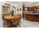 Inviting dining area with wood table and chairs, adjacent to a sunroom at 7462 Se 172Nd Fieldcrest St, The Villages, FL 32162