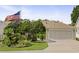 Home exterior with landscaped yard, driveway, and American flag at 7462 Se 172Nd Fieldcrest St, The Villages, FL 32162