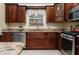 Elegant kitchen featuring stainless steel appliances, rich wooden cabinetry, and granite countertops at 7462 Se 172Nd Fieldcrest St, The Villages, FL 32162